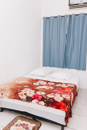 a bed in a room with a blue curtain at Guajará Palace Hotel in Porto Velho