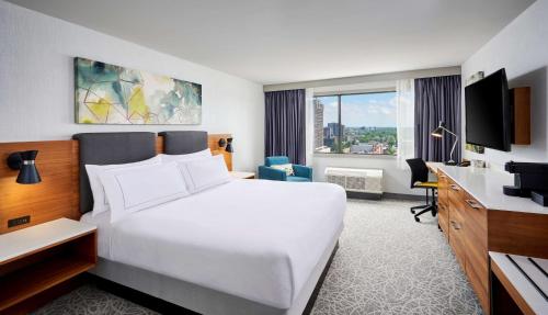 Pokój hotelowy z dużym białym łóżkiem i biurkiem w obiekcie DoubleTree by Hilton Windsor, ON w mieście Windsor
