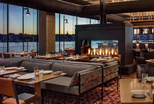 um restaurante com lareira e mesas e cadeiras em Canopy By Hilton Baltimore Harbor Point - Newly Built em Baltimore
