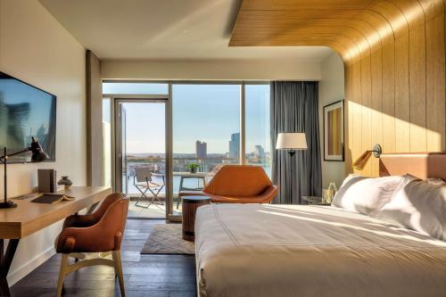 a hotel room with a bed and a desk and chair at Canopy By Hilton Baltimore Harbor Point - Newly Built in Baltimore