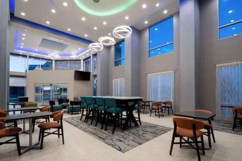 a dining room with tables and chairs and windows at Hampton Inn & Suites Gilroy, Ca in Gilroy
