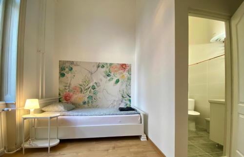 ウィーンにあるPension Wienderlandの壁に絵画が描かれたベッド付きの部屋