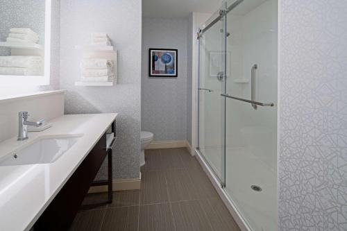 y baño con ducha y lavamanos. en Hampton Inn & Suites Gilroy, Ca en Gilroy