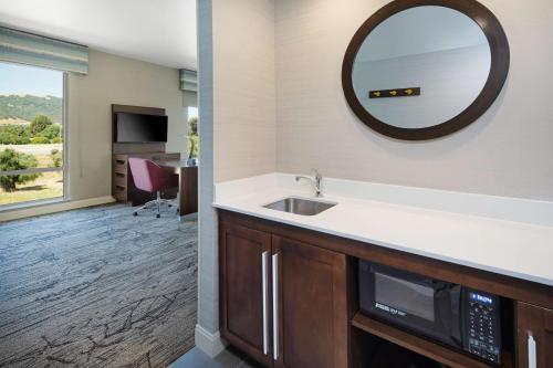 a kitchen with a sink and a mirror at Hampton Inn & Suites Gilroy, Ca in Gilroy
