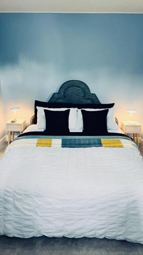 a large bed with black and white sheets and pillows at Deluxe 2 Bedroom Apartment in Sheffield