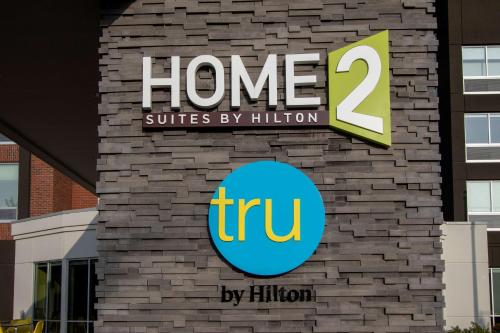 a sign that reads home suites by hilton on a brick wall at Tru By Hilton Grove City Columbus in Grove City