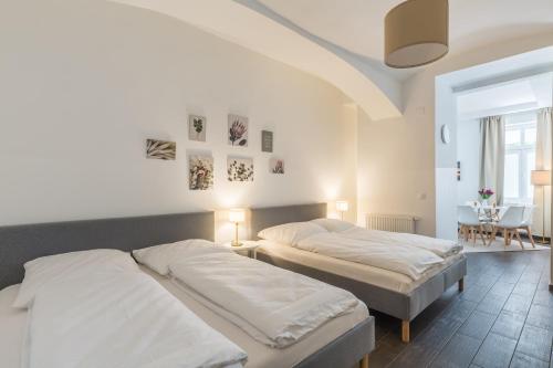 a bedroom with two beds and a table with a chair at Cozy Heaven in the lovely 2nd district of Vienna in Vienna