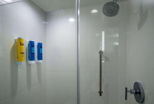 baño con ducha y 3 botellas en la pared en Tru By Hilton Grove City Columbus, en Grove City
