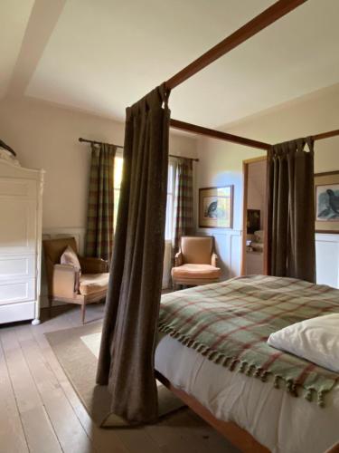 um quarto com uma cama de dossel e uma sala de estar em Lodge Saint-Hymer em Saint-Hymer
