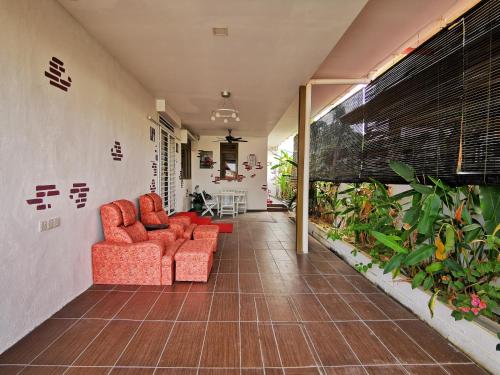 una sala de estar con 2 sillas rojas y plantas en Semi detached At Tabuan Jaya,13BR By Natol Homestay-London, en Kuching