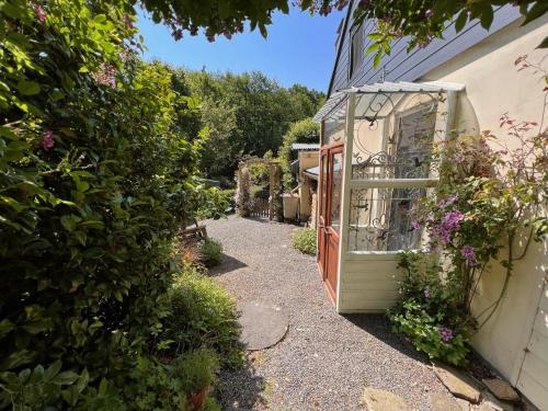 a garden entrance to a house with flowers at Les Trois Fenêtres in Beauficel