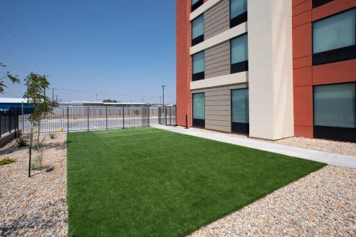 a green lawn in front of a building at Home2 Suites by Hilton Roswell, NM in Roswell