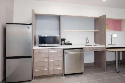 a kitchen with a refrigerator and a microwave at Home2 Suites by Hilton Roswell, NM in Roswell
