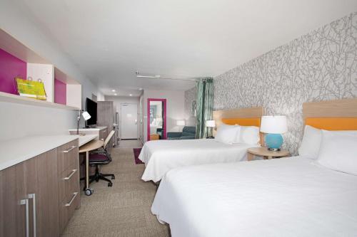 a hotel room with two beds and a desk at Home2 Suites by Hilton Roswell, NM in Roswell