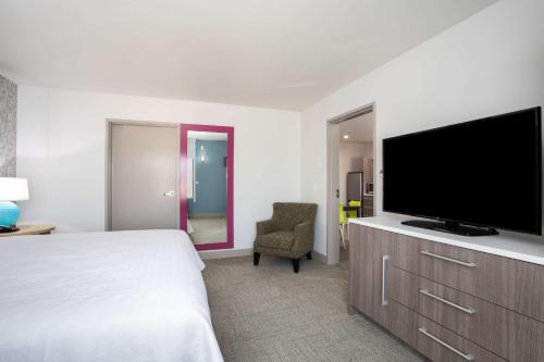 a hotel room with a bed and a flat screen tv at Home2 Suites by Hilton Roswell, NM in Roswell