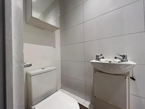 bagno bianco con servizi igienici e lavandino di Economic Studio in the heart of Chiswick - London a Londra