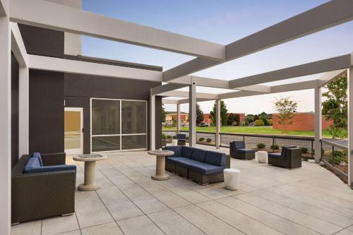 acovered patio with blue couches and tables on a building at Tru By Hilton Ringgold, Ga in Ringgold