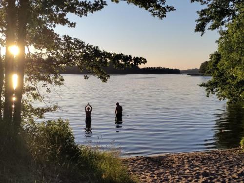 two people are standing in the water on a lake at Widny Jaś zaprasza na pięciobój równoczesny in Sulęczyno