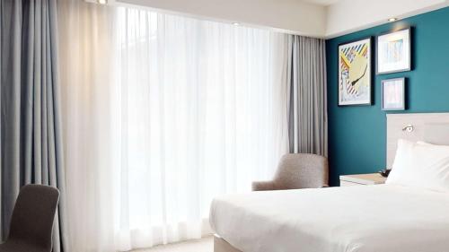 a hotel room with a bed and a large window at Hampton By Hilton Manchester Northern Quarter in Manchester