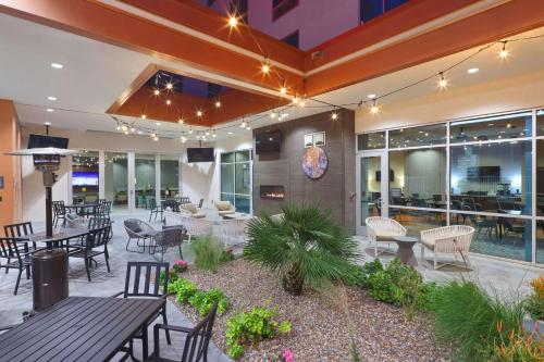 a patio with tables and chairs and a restaurant at Hilton Garden Inn Chandler Downtown in Chandler