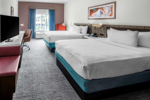 a hotel room with two beds and a desk at Hilton Garden Inn Chandler Downtown in Chandler