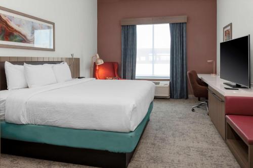 a hotel room with a bed and a television at Hilton Garden Inn Chandler Downtown in Chandler