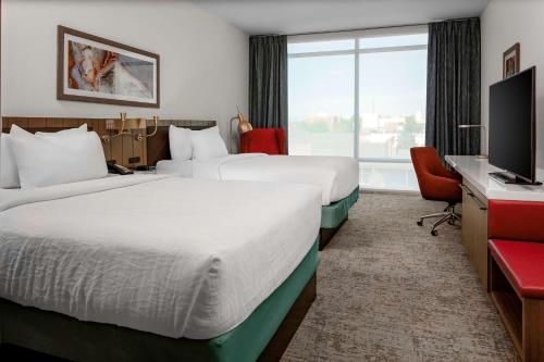 ein Hotelzimmer mit 2 Betten und einem Flachbild-TV in der Unterkunft Hilton Garden Inn Chandler Downtown in Chandler