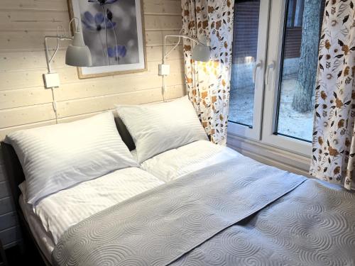 uma cama num quarto com uma janela em Domki - Sosnowy Las em Pobierowo