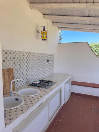bagno con 2 lavandini e bancone con piano cottura di Villa Paso a Ustica
