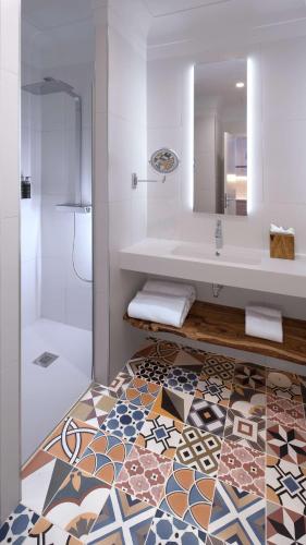 a bathroom with a tub and a sink and a mirror at Atocha Hotel Madrid, Tapestry Collection by Hilton in Madrid
