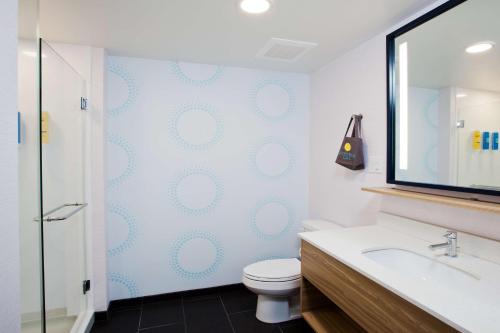 a bathroom with a toilet and a sink and a mirror at Tru By Hilton Prattville in Prattville