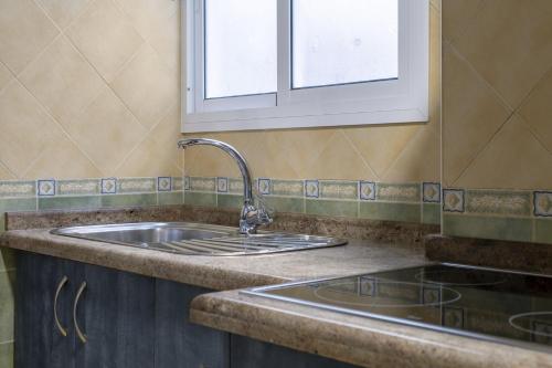 a kitchen with a sink and a window at Paseo Larios Torre del Mar in Torre del Mar