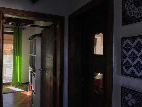 um corredor com uma porta preta e uma cortina verde em The Refuge em Bachevo