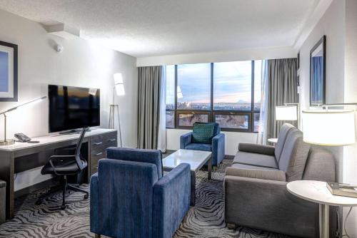 a hotel room with a living area with a television at DoubleTree by Hilton Calgary North in Calgary
