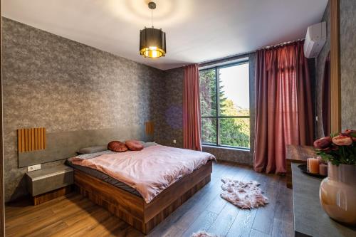 a bedroom with a bed and a large window at Metalex Garden 2bdrm Luxury Apartment in Varna City
