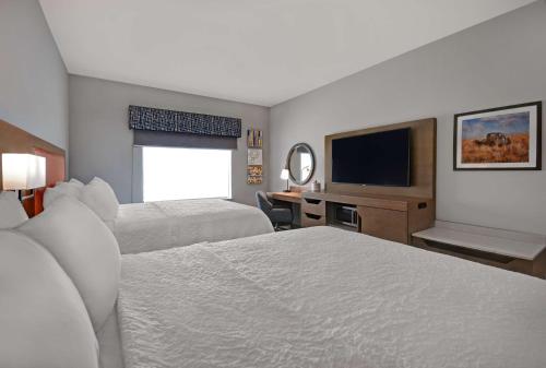 ミッドランドにあるHampton Inn Midland South, Txのベッド2台、薄型テレビが備わるホテルルームです。