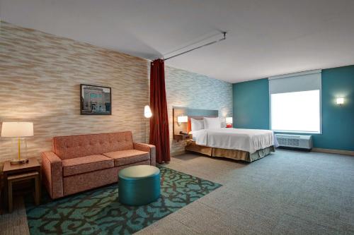 a hotel room with a bed and a couch at Home2 Suites By Hilton Fort Mill, Sc in Fort Mill