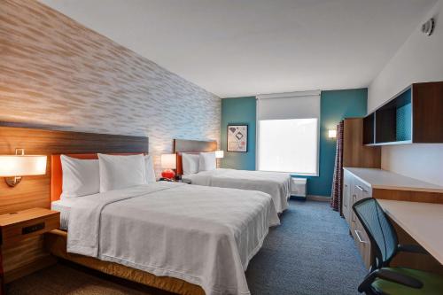 a hotel room with two beds and a window at Home2 Suites By Hilton Fort Mill, Sc in Fort Mill