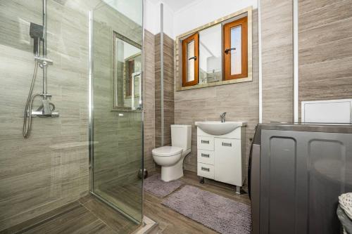 a bathroom with a toilet and a glass shower at Rectorate Apartment in Plovdiv