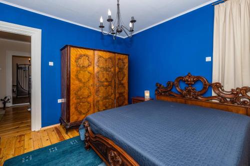 a blue bedroom with a bed and a blue wall at Rectorate Apartment in Plovdiv