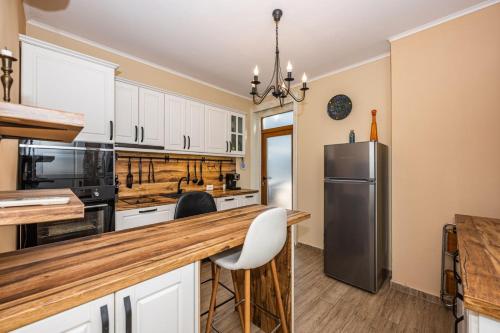 a kitchen with white cabinets and a stainless steel refrigerator at Rectorate Apartment in Plovdiv