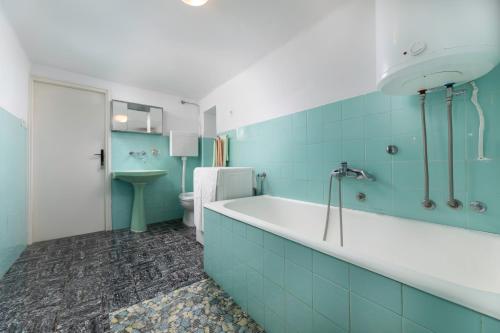 a blue bathroom with a tub and a toilet at Apartment Dunato in Polje