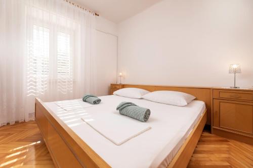 a bedroom with a large white bed with two pillows at Apartment Dunato in Polje