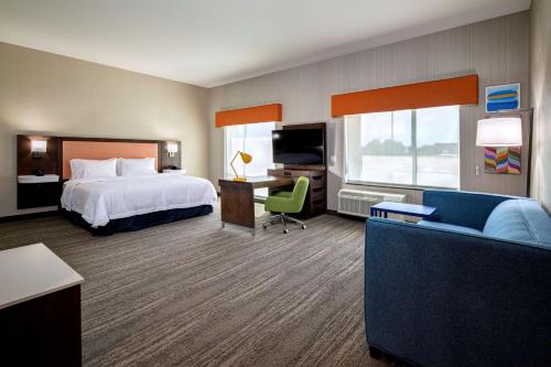 a hotel room with a bed and a couch at Hampton Inn & Suites Indio, Ca in Indio