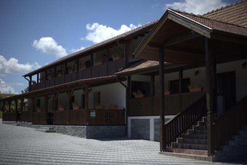 a building with a porch and stairs on it at Bingyó Vendégház in Lupeni
