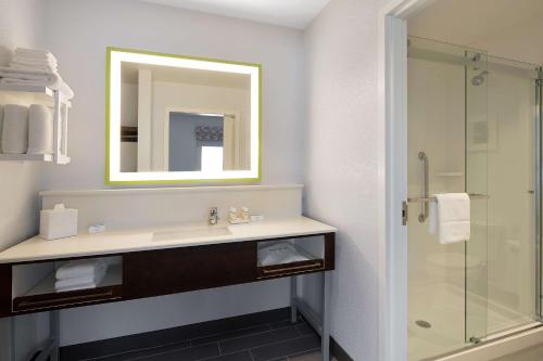 a bathroom with a sink and a shower at Hampton Inn & Suites Raleigh Midtown, NC in Raleigh