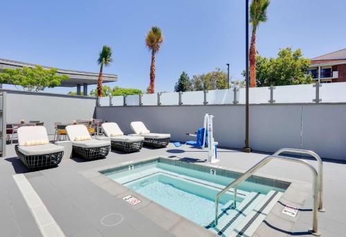 a swimming pool with lounge chairs and a patio with a swimming pool at Hampton Inn by Hilton Irvine Spectrum Lake Forest in Lake Forest