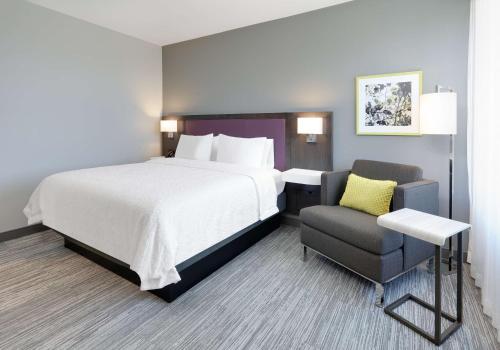 Habitación de hotel con cama y silla en Hampton Inn by Hilton Irvine Spectrum Lake Forest en Lake Forest