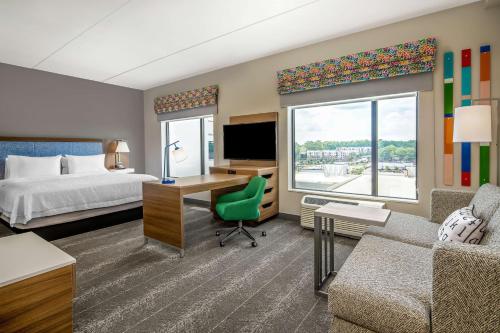 ローリーにあるHampton Inn & Suites Raleigh Midtown, NCのベッド、デスク、コンピュータが備わるホテルルームです。