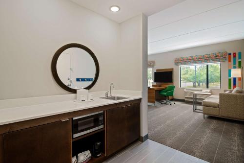 a bathroom with a sink and a mirror in a room at Hampton Inn & Suites Raleigh Midtown, NC in Raleigh